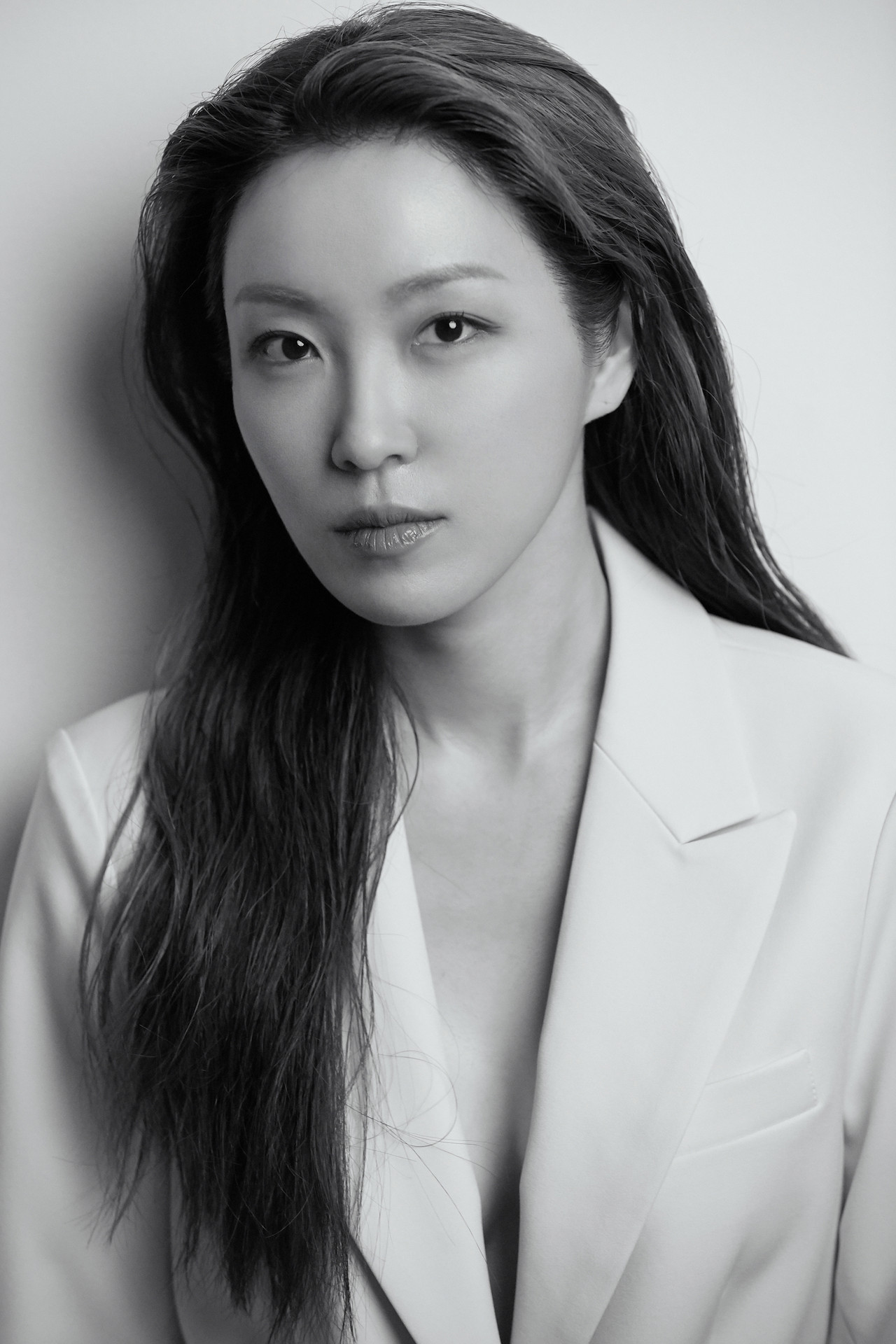 Minae Elena Kim, black and white portrait in a white blazer